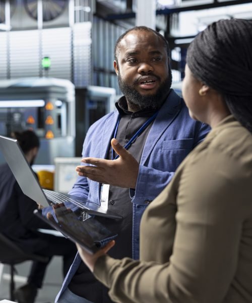 African american team of energy consultants analyzing insight in solar panel plant, ensuring high standards in renewable energy production line, quality control and manufacturing efficiency.