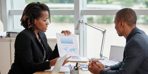 Business woman showing diagram and explaining information to entrepreneur